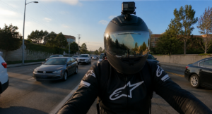 Motorcyclist wearing helmet camera riding through traffic capturing road footage
